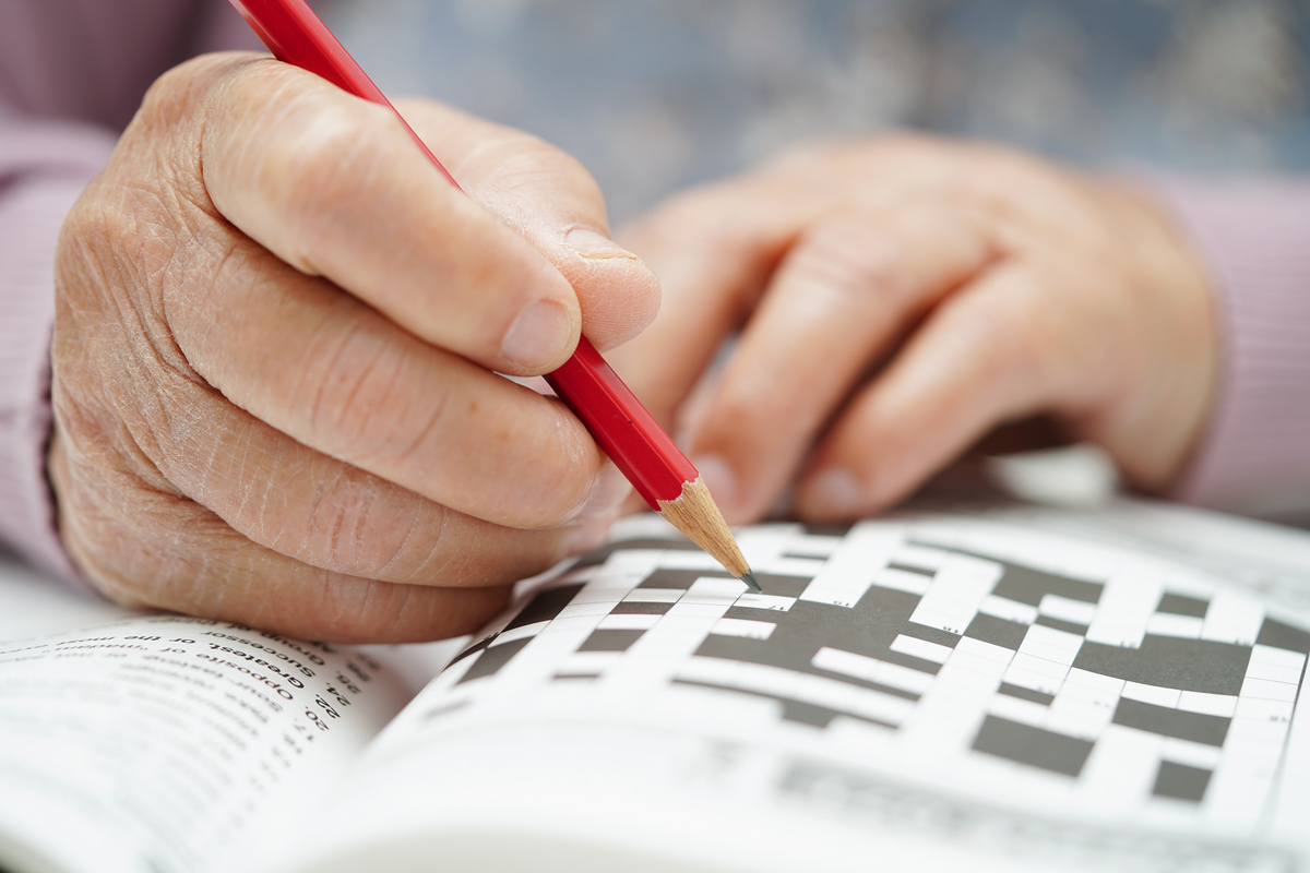 Asian elderly woman playing sudoku puzzle game to practice brain training for dementia prevention, Alzheimer disease.